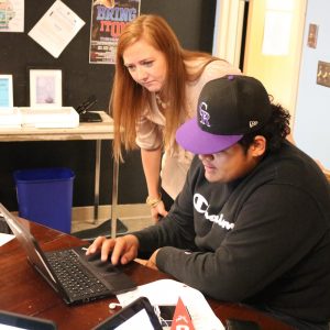Counselor assists student with college application.