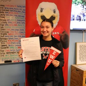 Student smiling with college acceptance letter.